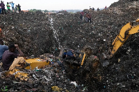 Rescue workers search through a heap of refuse after it collapsed at Conakry’s largest landfill