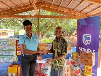 Abiana Nelson (left) presenting the items to the caretaker of the home, Mr. Adu Amoako