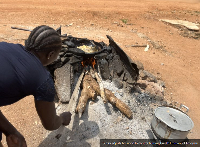 Suzzy adjusts firewood to control burning Credit: Emmanuel Ameyaw