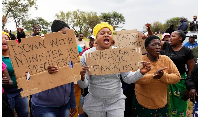 Relatives and friends protest near the gold mine where miners are trapped in Stilfontein, South Afri