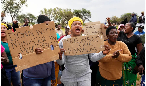 Relatives and friends protest near the gold mine where miners are trapped in Stilfontein, South Afri