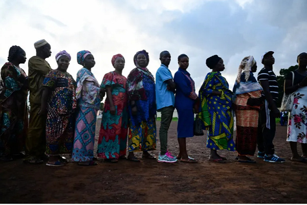 People wait to cast their votes for the national elections at a polling station in Freetown
