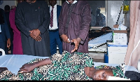 Kwara state Gov. Abdulrahman Abdulrazaq, left, visits a woman receiving medical attention