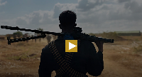 A Somalia National Army soldier with ammunition belts strapped around him  on the frontline