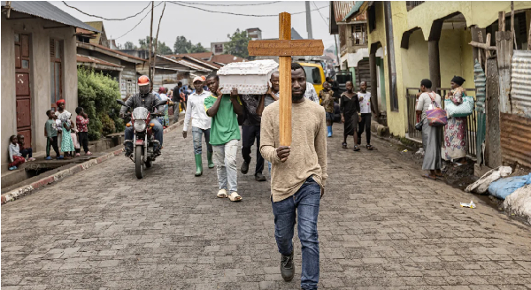 A man carries a cross during a funeral procession in Goma on February 4