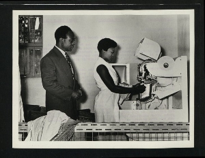 Dr Nkrumah watches a Ghanaian operator at work on a machine producing metal labels in a factory