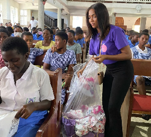 One of the FHUC staff sharing the sanitary pads to some girls