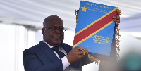 Felix Tshisekedi holds up the constitution during the inauguration ceremony