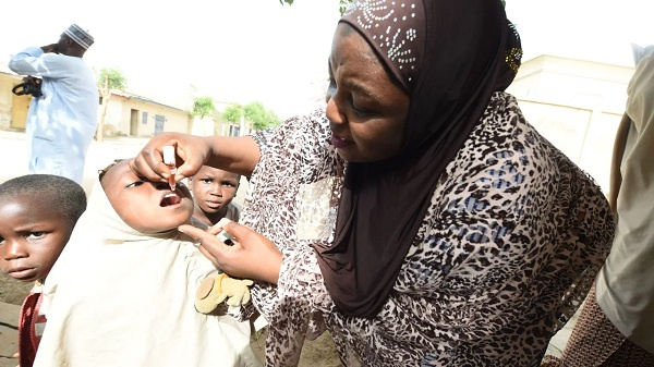 A health official tries to immunize a child during a vaccination campaign in Kano