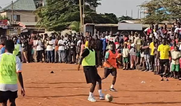 Doku playing football with some locals in Madina