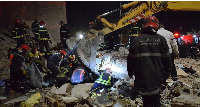 Emergency personnel search for victims in the rubble of two collapsed buildings in the Al Massira