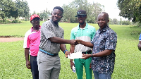 Lucky Ayisah (L) receiving the winner's cheque from Prof Benard Kofi Baiden ( R)