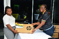 MTN Bright Scholarship beneficiary receiving a laptop and airtime from Cynthia Mills
