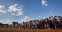 Voters who had waited in line for many hours queue at sunset to vote at a polling station