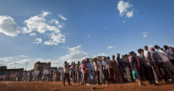 Voters who had waited in line for many hours queue at sunset to vote at a polling station