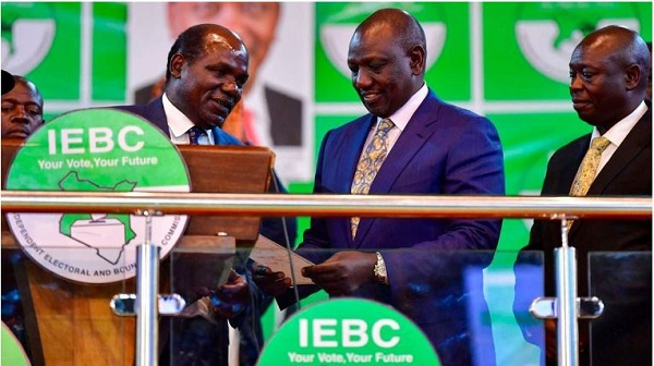 Wafula Chebukati (left) hands William Ruto his certificate after being declared president-elect