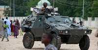 Nigerian soldiers ride on an armored personnel carrier during Eid al-Fitr celebrations in Maidugur
