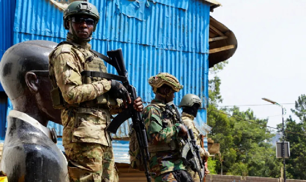 Members of the M23 rebel group stand guard as people attend a rally addressed by Corneille Nangaa
