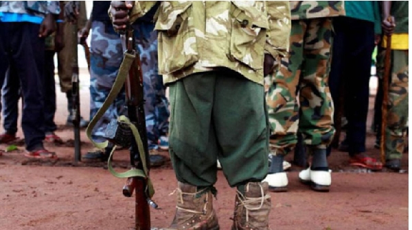 A former child soldier holds a gun as they participate in a child soldiers' release ceremony