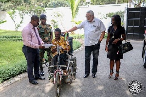 Former President Jerry John Rawlings with Emmanel Ofoe, the physically challenged street beggar