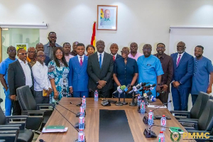 Some members of the committee in a photo with the Finance minister [in suit and blue tie]