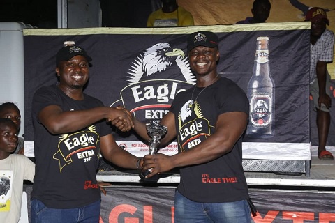 Derrick Kwakye receiving his prize from John Baptist Akado, Brands Manager of  Eagle Extra Stout