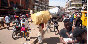 Traders carry sacks of merchandise in Kampala