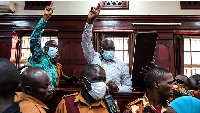 Uganda's veteran opposition leader Kizza Besigye, (L), and his aide Obeid Lutale, gesture at court