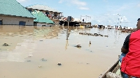 An official of the Nigerian Red Cross Society canoes through a submerged market in Lokoja
