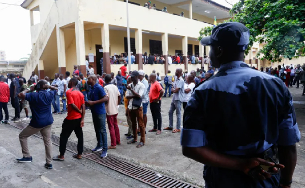 People wait to cast their votes on Saturday outside a school used as a polling station