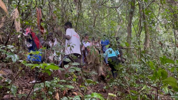 Locals at the scene of the crash site picking up the debris of the helicopter