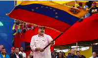 Venezuela's President Nicolas Maduro waves a flag during an event
