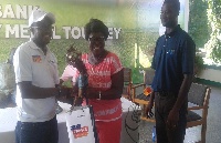 Lady Capo (middle) receiving her prize from an official of Access