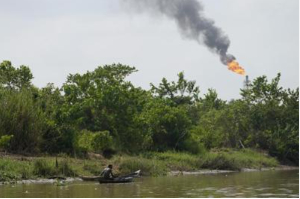 A man paddle his canoe past a gas flare in the Niger Delta near the village of Ogboinbiri, Nigeria A man paddle his canoe past a gas flare in the Niger Delta near the village of Ogboinbiri, Nigeria