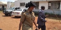 Police escorting Moses Kanyarutokye, Mpigi District Chief Administrative Officer to cells