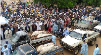 Trucks carry the wrapped bodies of people killed by suspected Boko Haram militants