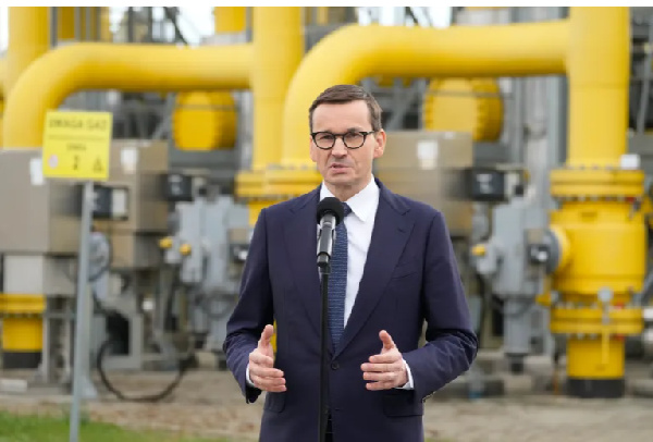 Poland's Prime Minister Mateusz Morawiecki speaks to media at the gas station