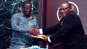 Roads Minister , Kwasi Amoako-Atta receiving the first copy of the book from Dr. Samuel Nikoi