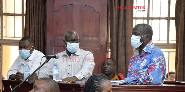 Dr Kizza Besigye (R) and his co-accused Obeid Lutale (C) and Captain Denis Oola appear in court