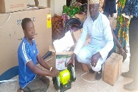 One of the beneficiaries (L) receiving an equipment from the Assembly