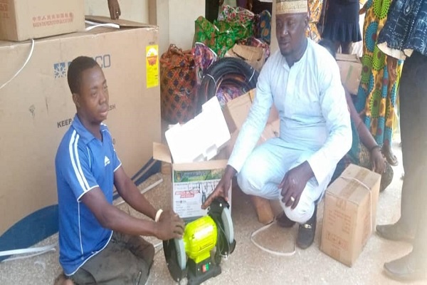 One of the beneficiaries (L) receiving an equipment from the Assembly