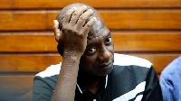 Pastor Paul Mackenzie holds his head during a court session at Mombasa Law Courts in Mombasa County