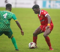 Asante Kotoko's Eric Zeze (in red) in actions against Nsoatreman FC