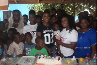 Ahoufe Patri with the kids and some friends cutting her birthday cake