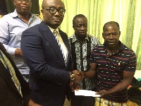The CEO of EIB Network Bola Ray presenting a cheque to Amakye Dede