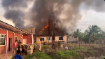 An image of the intense orange flames engulfing the roof of a light-colored building