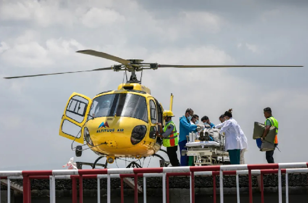 Medics and rescuers transfer mountaineer Dawa Sherpa from helicopter upon his arrival at a hospital