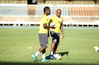 Asamoah Gyan standing with Andre Ayew