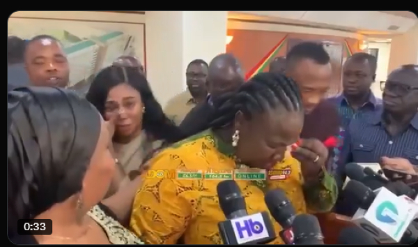 A screenshot shows Gloria Owusu wiping her face whiles speaking with the media