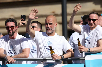 Manchester City manager Pep Guardiola, centre, takes part in an open-top bus parade in Manchester